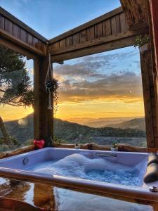 a bath tub in a room with a view at Pousada Flocos de Neve in Urubici