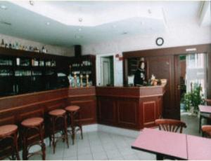 a restaurant with a bar with stools at Hotel du Gambrinus in Hazebrouck