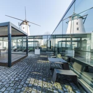 two windmills on the roof of a building with benches at D-Hotel in Kortrijk