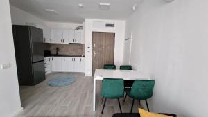 a kitchen with a white table and green chairs at West Homes 34 in Oradea