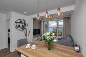 a living room with a table with a vase of flowers at Apartman Pelagos in Živogošće