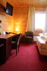 a hotel room with a desk and a bed and a desk and chairs at Hotel Framtid in Djúpivogur