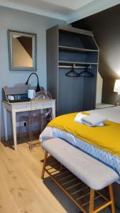 a bedroom with a bed and a desk and a table at Les coquelicots - Chambre Alex in Houdan