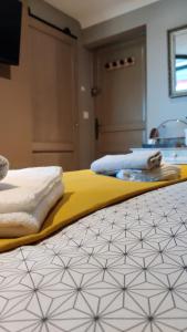 a bedroom with two beds with towels on the floor at Les coquelicots - Chambre Alex in Houdan