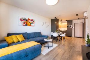 Il comprend un salon avec un canapé bleu et une cuisine. dans l'établissement MF Coral Beach Apartment, à Siófok