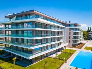 un immeuble d'appartements avec une piscine en face dans l'établissement MF Coral Beach Apartment, à Siófok