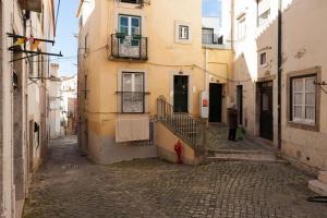 een persoon die door een straat loopt in een steegje bij Alfama Vintage 1 Ten guests - Alfama Vintage 2 Five guests - Alfama Vintage 3 Three Guests in Lissabon