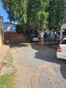 a driveway with two cars parked in front of a house at Suíte 08 - Aconchegante e Exclusiva in Cuiabá