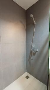 een douche met een douchekop in de badkamer bij Ruby Apartment #7 in Kejayan