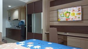 een kamer met een keuken en een televisie aan de muur bij Ruby Apartment #7 in Kejayan