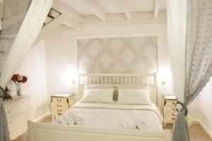 een slaapkamer met een wit bed en 2 nachtkastjes bij Rubichi Luxury Apartment in Galatone