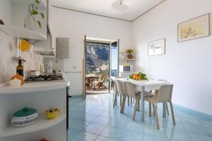 a kitchen with a white table and chairs in a room at Casa la Perla in Positano