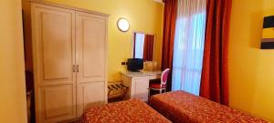 a hotel room with a bed and a desk with a television at Alle Torri in Marghera