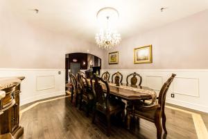une salle à manger avec une table, des chaises et un lustre dans l'établissement DowntoWn Abbey, à Saint-Louis