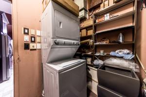 a small kitchen with a refrigerator and shelves at DowntoWn Abbey in Saint Louis