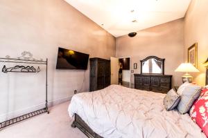 - une chambre avec un lit et une télévision murale dans l'établissement DowntoWn Abbey, à Saint-Louis