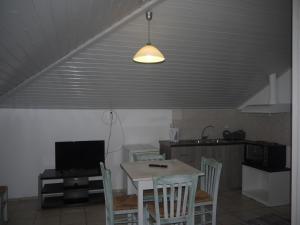 a kitchen with a table with chairs and a television at Hotel Akropolis in Sivota