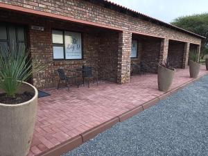 a brick building with a patio with chairs and tables at Big D Accommodation & guesthouse in Northam