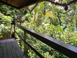 a wooden porch with a bench in a garden at chale pouso da mariposa in Praia Vermelha
