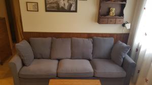 un sofá sentado en una sala de estar junto a una pared en WIFI COMO EN TU CASA Canfranc Estación, en Canfranc-Estación