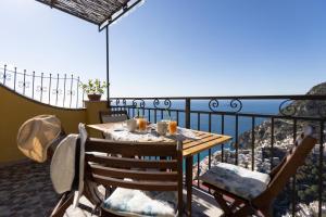 a table on a balcony with a view of the ocean at Casa la Perla in Positano