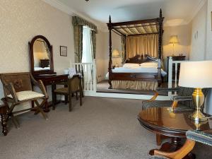 a large bedroom with a bed and a desk and a table at Chandlers BnB in Seahouses