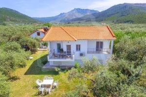 una pequeña casa blanca con techo naranja en un campo en Elena's Suite en Skala Rachoniou