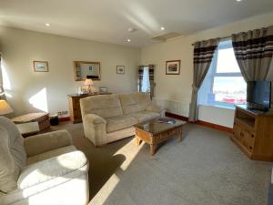 a living room with a couch and a tv at Chandlers BnB in Seahouses +16 photos
