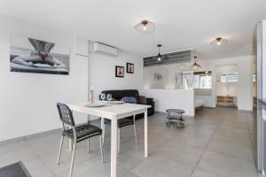 een keuken en een woonkamer met een witte tafel en stoelen bij Village Naturiste R4N - Le Rocca V Héliopolis Luxe in Cap d'Agde