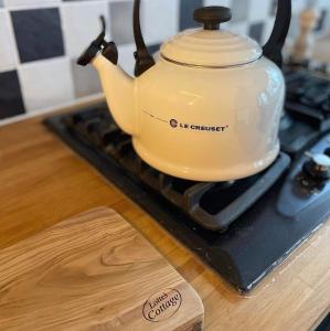 a tea kettle sitting on top of a stove at Lotte’s Cottage in Bideford