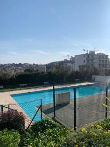 a swimming pool with a fence around it at Studio with a panoramic view at the last floor of the residence with a pool in Antibes