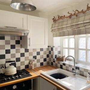 cocina con fregadero y fogones en Lotte’s Cottage, en Bideford