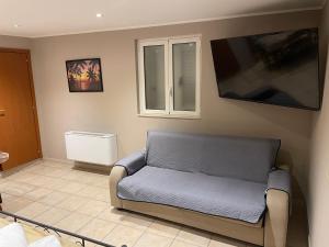 uma sala de estar com um sofá e uma televisão de ecrã plano em Del Corso Apartment Palese Airport em Bari