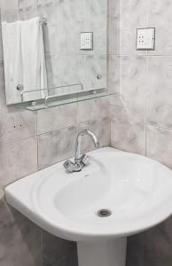 lavabo blanco en el baño con espejo en 1 Kanal Entire House with 4 Bedrooms, en Lahore