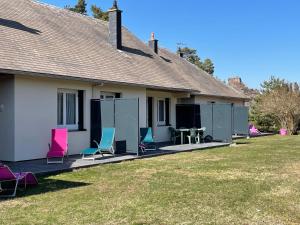 ein Haus mit Stühlen und Tischen im Hof in der Unterkunft Les Gîtes du Paradis in Murol