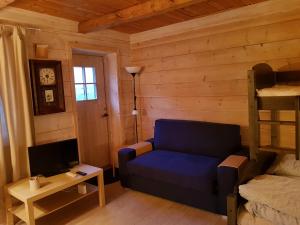 a living room with a blue couch and a bed at Rongen gard in Bolstadøyri