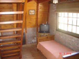 1 dormitorio con litera y TV en Cabañas Ecos del Rio en Los Reartes