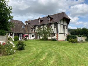 une grande maison avec une grande pelouse dans l'établissement La pommeraie76, à Saint-Ouen-sous-Bailly