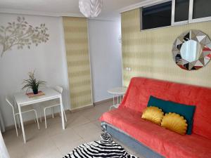 uma sala de estar com um sofá vermelho e uma mesa em MY SUNNY PAYMA BEACH Apartment em Benidorm