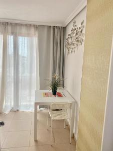 uma mesa branca e cadeira num quarto com uma janela em MY SUNNY PAYMA BEACH Apartment em Benidorm