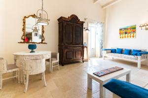 ein Wohnzimmer mit einem blauen Sofa und einem Tisch in der Unterkunft Blue Levante Vista Mare con terrazza in Syrakus