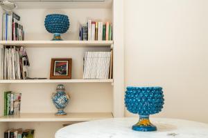 three blue vases sitting on a table in a book shelf at Blue Levante Vista Mare con terrazza in Syracuse