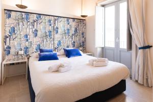 a bedroom with two beds with blue and white pillows at Blue Levante Vista Mare con terrazza in Syracuse