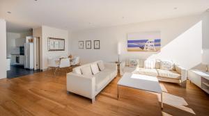 a living room with white furniture and a table at Sandcastle Apartments in Port Macquarie
