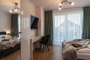 a bedroom with two beds and a desk and a window at Bałtycka Głębia in Gąski