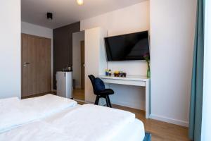 a bedroom with two beds and a desk with a tv at Bałtycka Głębia in Gąski