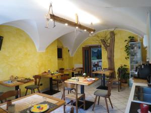 un restaurante con mesas de madera y sillas en una habitación en B&B da Erica en Comano Terme