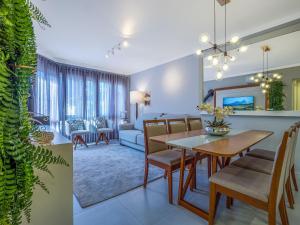 a dining room and living room with a table and chairs at Residencial St. Petrus! in Gramado