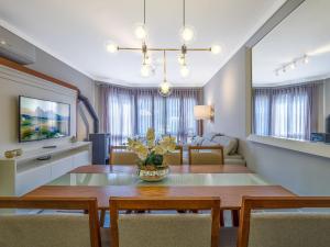 a dining room with a table and a living room at Residencial St. Petrus! in Gramado