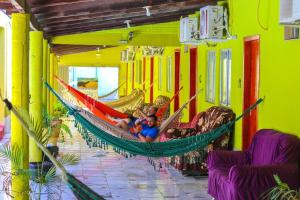 a group of children laying in a hammock in a room at Pousada Aquarius in Aruanã